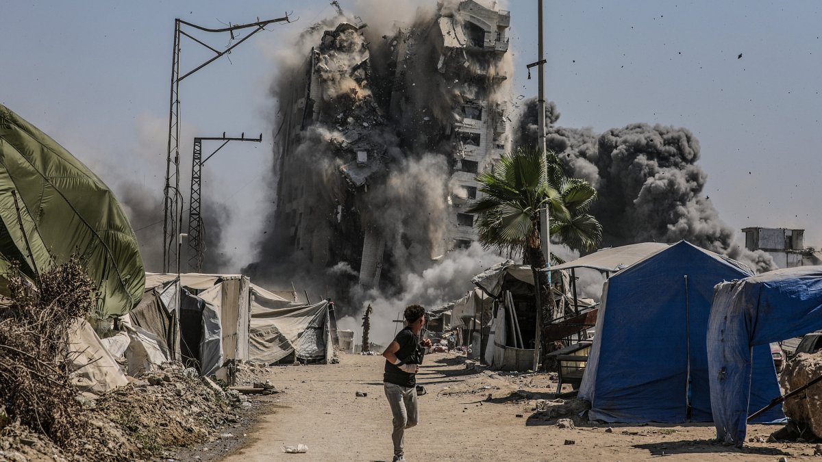 A boy runs as the Mushtaha Tower collapses following an Israeli airstrike in the west of Gaza City, Gaza Strip, Sept. 5, 2025. (EPA Photo)