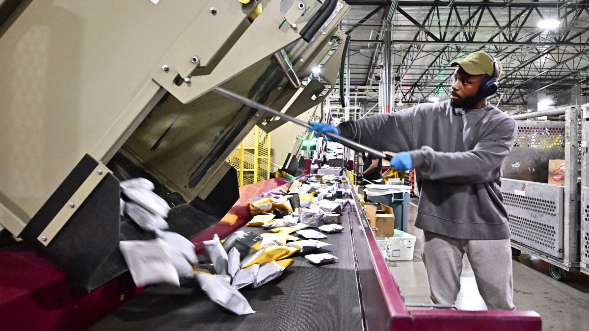 Postal workers sort through mail and packages during a media tour hosted by the U.S. Postal Service at the Los Angeles Processing and Distribution Center, Los Angeles, U.S., Nov. 30, 2023. (AFP Photo)