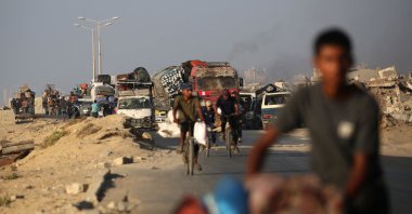 Palestinians fleeing south, ride vehicles and bicycles with their belongings, on the coastal road near the Nuseirat refugee camp in the central Gaza Strip, Aug. 5, 2025. (AFP Photo)