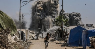 A boy runs as the Mushtaha Tower collapses following an Israeli airstrike in the west of Gaza City, Gaza Strip, Sept. 5, 2025. (EPA Photo)