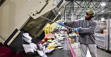 Postal workers sort through mail and packages during a media tour hosted by the U.S. Postal Service at the Los Angeles Processing and Distribution Center, Los Angeles, U.S., Nov. 30, 2023. (AFP Photo)