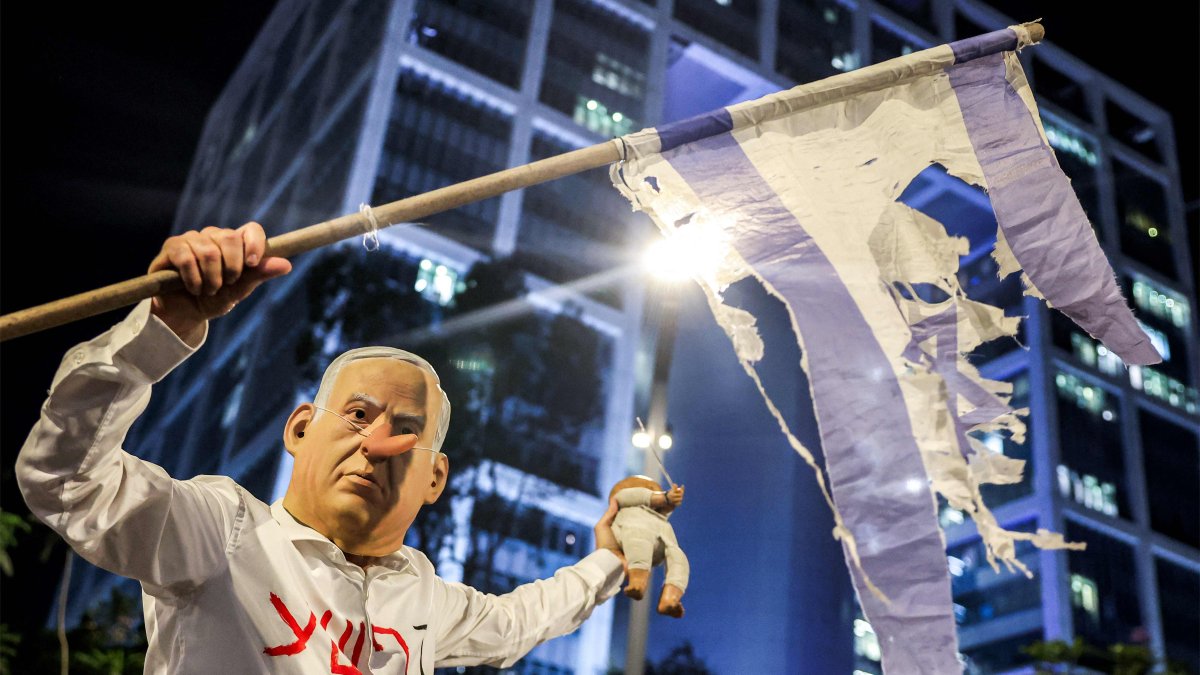 A demonstrator wearing a mask depicting Israeli Prime Minister Benjamin Netanyahu with an elongated nose, evoking the literary character Pinocchio, poses during an anti-government protest, Tel Aviv, Israel, Aug. 23, 2025. (AFP Photo)