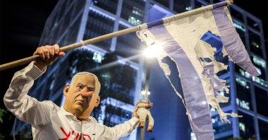 A demonstrator wearing a mask depicting Israeli Prime Minister Benjamin Netanyahu with an elongated nose, evoking the literary character Pinocchio, poses during an anti-government protest, Tel Aviv, Israel, Aug. 23, 2025. (AFP Photo)