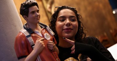 A worshipper poses for a picture with the statue of Carlo Acutis, a British-born Italian boy who became the first millennial Catholic saint, Sao Paulo, Brazil, Sept. 7, 2025. (Reuters Photo)