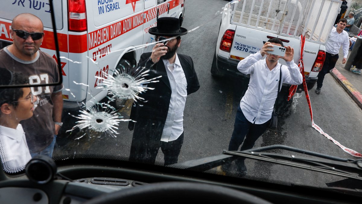 People inspect a bus with bullet holes at the scene where a suspected shooting attack took place at the outskirts of Jerusalem, September 8, 2025 REUTERS/Ammar Awad