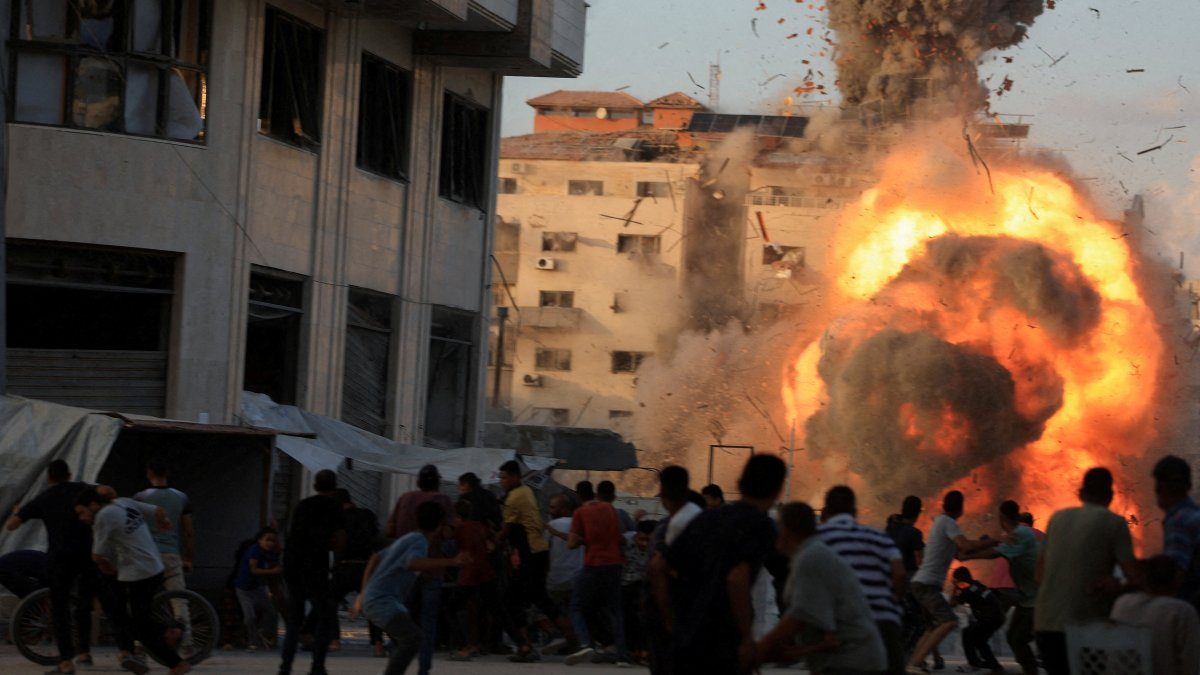 Palestinians react, as smoke and flames rise while a residential building collapses after an Israeli airstrike, in Gaza City, Palestine, Sept. 7, 2025. (Reuters Photo)