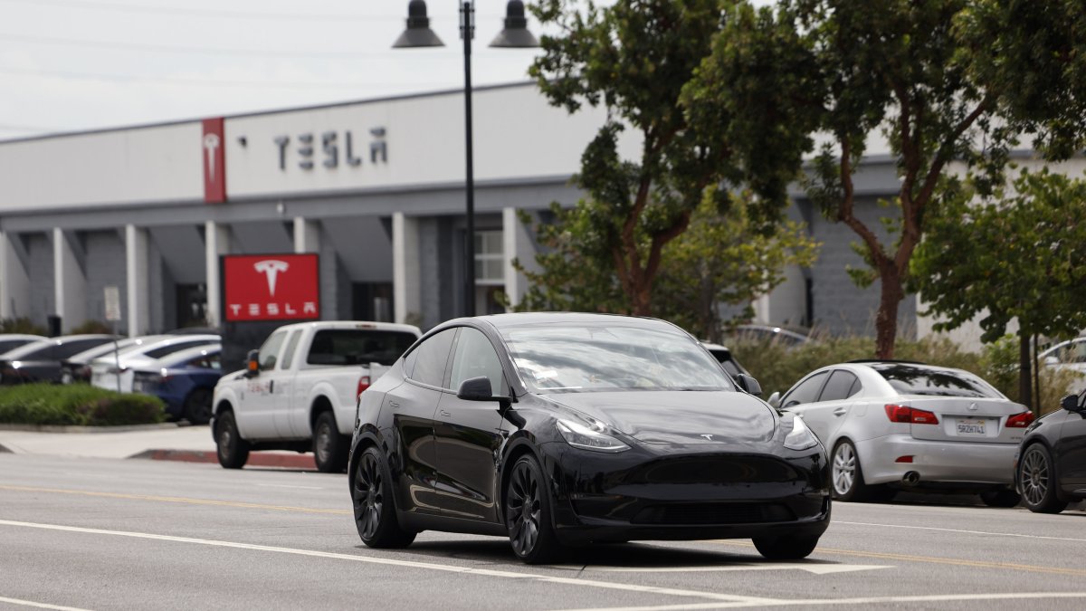 A Tesla car drives by a Tesla showroom, Burbank, California, U.S., Aug. 28, 2025. (EPA Photo)