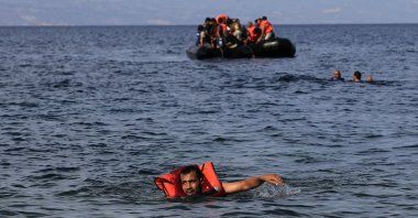 A man swims to the shore as refugees from Syria arrive on a dinghy at the coast of Mytilini, Lesvos, Greece, Sept. 9, 2015. (EPA Photo)