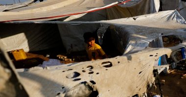 A child looks on as Palestinians inspect the site of an overnight Israeli strike on a tent, Gaza City, Palestine, Sept. 8, 2025. (Reuters Photo)