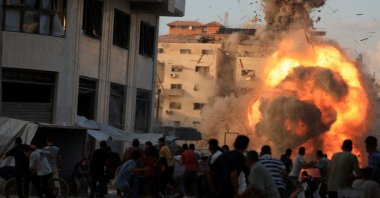 Palestinians react, as smoke and flames rise while a residential building collapses after an Israeli airstrike, in Gaza City, Palestine, Sept. 7, 2025. (Reuters Photo)
