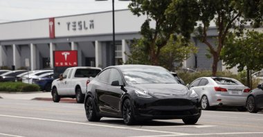 A Tesla car drives by a Tesla showroom, Burbank, California, U.S., Aug. 28, 2025. (EPA Photo)