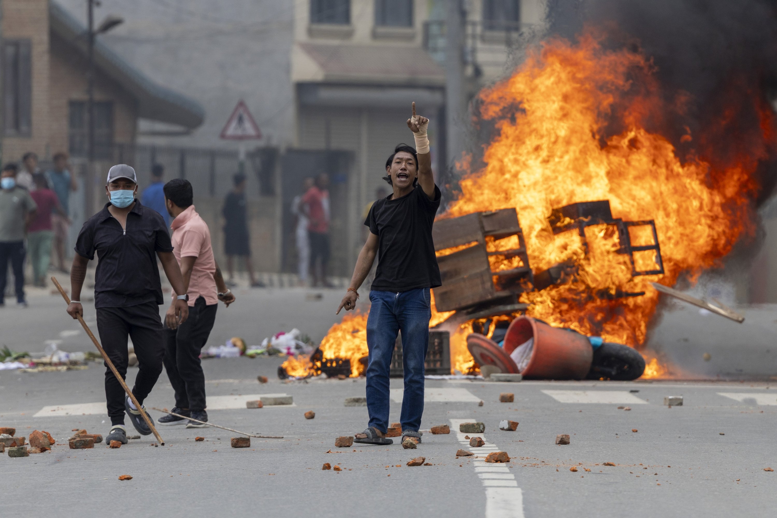 La gente se encuentra cerca de las barricadas ardientes durante las protestas en Katmandú, Nepal, 9 de septiembre de 2025. (Foto de la EPA)