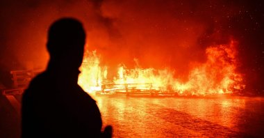 A man watches objects burn after being set ablaze by protesters during a demonstration as part of the "Bloquons Tout" ("Block Everything") protest movement, Caen, France, Sept. 10, 2025. (AFP Photo)