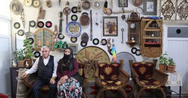 Bilal Kambur and his wife, Nezahat, sit among antique items from their 1,000-piece collection at their home, Nevşehir, Türkiye, Sept. 10, 2025. (AA Photo)