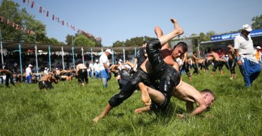 Wrestlers grapple during the 65th Traditional Kurtdereli Mehmet Pehlivan Oil Wrestling Festival, hosted by Balıkesir Metropolitan Municipality and Karesi Municipality, at Kurtdere Arena, Balıkesir, Türkiye, Aug. 22, 2025. (AA Photo)