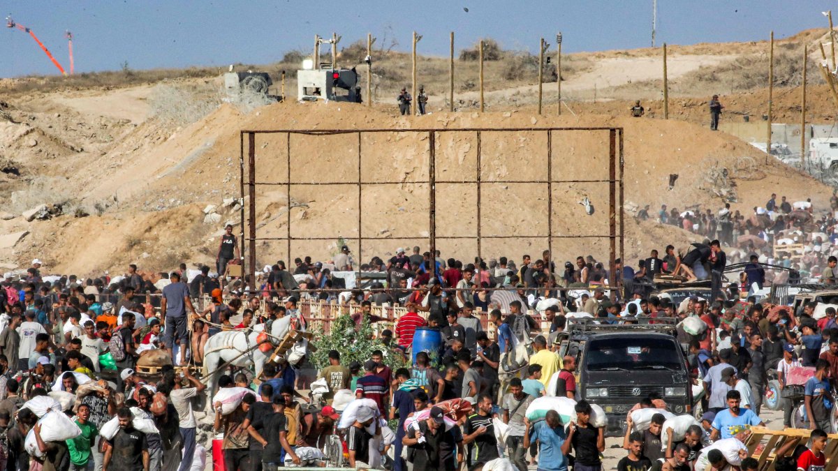 People walk with bags of humanitarian aid they received at a distribution centre run by the U.S. and Israeli-backed GHF, central Gaza Strip, Palestine, Aug. 22, 2025. (AFP photo)