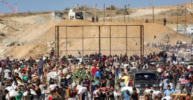 People walk with bags of humanitarian aid they received at a distribution centre run by the U.S. and Israeli-backed GHF, central Gaza Strip, Palestine, Aug. 22, 2025. (AFP photo)