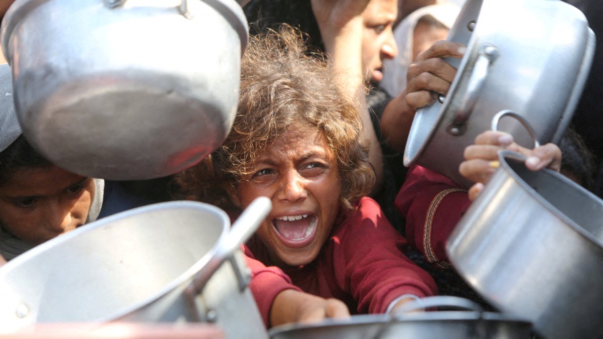 A Palestinian child cries among cooking pots as people wait for food from a charity kitchen in Khan Younis, Gaza Strip, Palestine, Aug. 21, 2025. (Reuters Photo)