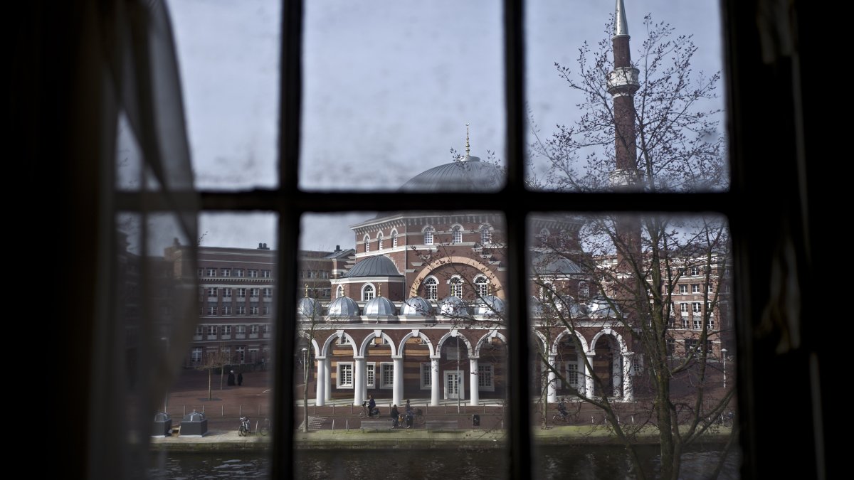 Seen through the window of an apartment, people ride their bikes past a mosque in Amsterdam, Netherlands, Monday, March 13, 2017. (AP File Photo)
