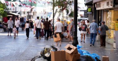 Overflowing garbage piles cover a busy street, creating strong odors and disrupting daily life, Izmir, Türkiye, Sept. 11, 2025. (AA Photo)