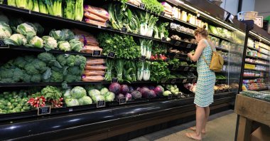 A customer looks at vegetables on display in a grocery store, Delray Beach, Florida, U.S., Aug. 15, 2025. (AFP Photo)