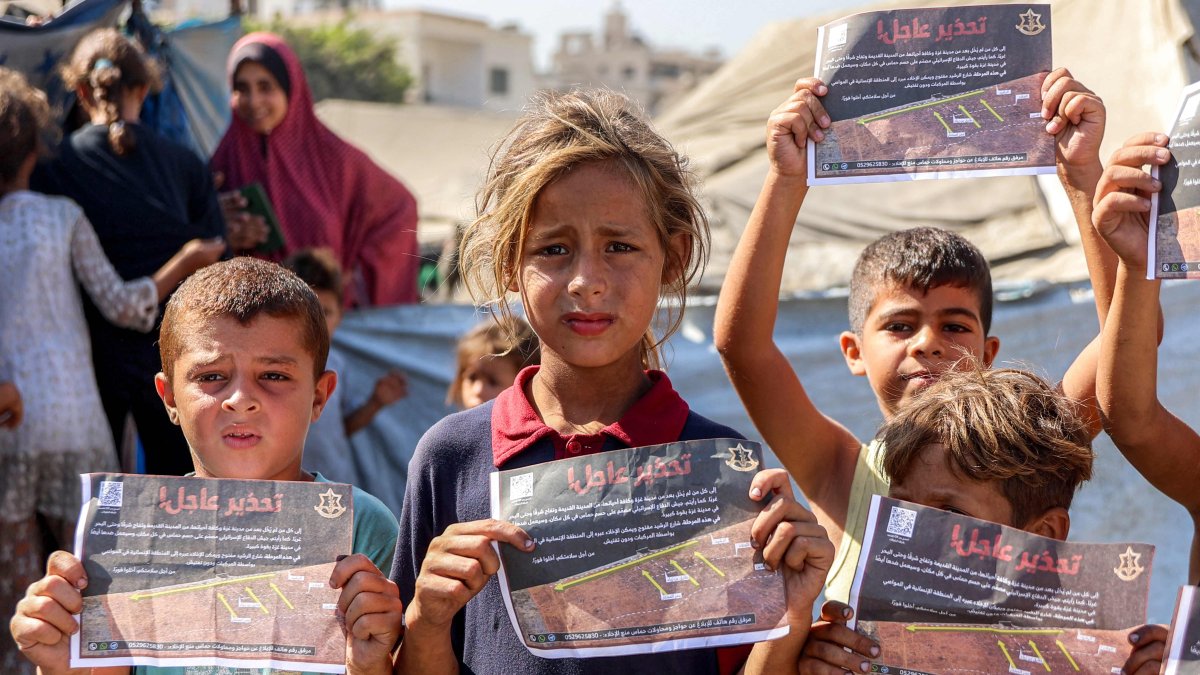 Children hold some of the leaflets dropped by the Israeli military, urging evacuation to al-Mawasi in the southern Gaza Strip, in Gaza City, Sept. 12, 2025. (AFP Photo)