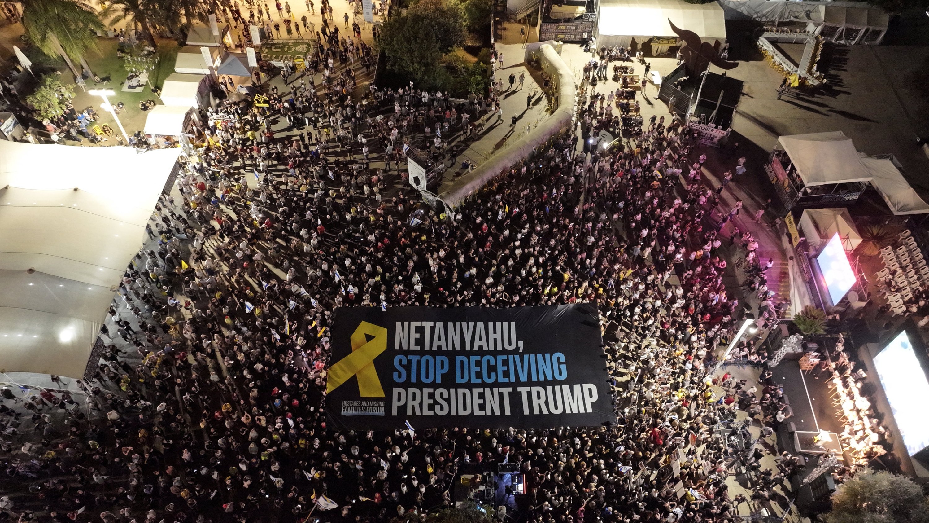 Hundreds of protesters, gathered at 'Hostage Square,' unfurl a giant banner reading 'Netanyahu, stop deceiving President Trump,' Tel Aviv, Israel, Sept. 13, 2025. (AA Photo)