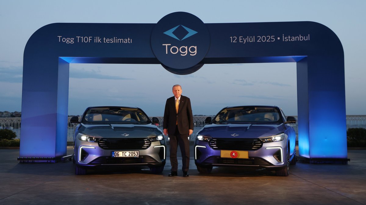 President Recep Tayyip Erdoğan stands between two models of Togg&#039;s T10F electric sedan, Istanbul, Türkiye, Sept. 12, 2025. (AA Photo)
