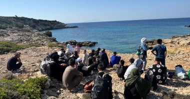 A group of irregular migrants intercepted by Turkish authorities before leaving for Greece wait on the coast, Izmir, western Türkiye, Sept. 14, 2025. (IHA Photo)
