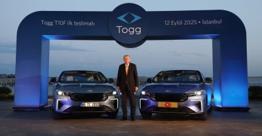 President Recep Tayyip Erdoğan stands between two models of Togg&#039;s T10F electric sedan, Istanbul, Türkiye, Sept. 12, 2025. (AA Photo)