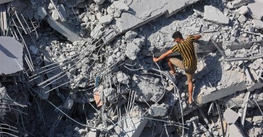 A Palestinian youth climbs the rubble of al-Ghafari tower after its destruction by Israeli airstrikes in Gaza City, northern Gaza Strip, Palestine, Sept. 15, 2025. (AFP Photo)