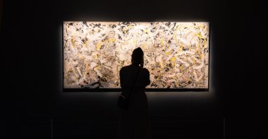 A visitor looks at a Jackson Pollock artwork, Rome, Italy, Nov. 10, 2018. (Shutterstock Photo)