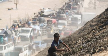 A Palestinian boy walks up a dump site, as displaced Palestinians flee northern Gaza due to an Israeli military operation, Gaza Strip, Palestine, Sept. 14, 2025. (Reuters Photo)