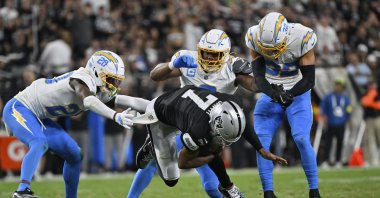 Los Angeles Chargers cornerback Cam Hart (L) tackles Las Vegas Raiders quarterback Geno Smith (C) during the first half of an NFL football game, Monday, Las Vegas, U.S., Sept. 15, 2025. (AP Photo)