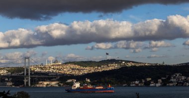 Residential buildings are seen in the background as a cargo ship sails through the Bosporus in Istanbul, Türkiye, Sept. 15, 2025. (Reuters Photo)
