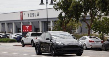 A Tesla car drives by a Tesla showroom in Burbank, California, Aug. 28, 2025. (EPA Photo)