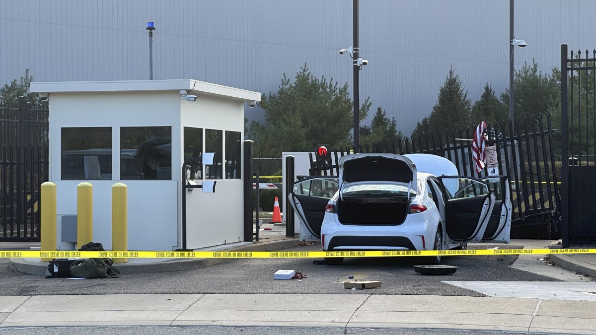 FBI officials inspect a car that rammed into a gate at the FBI building in Pittsburgh, Wednesday, Sept. 17, 2025. (AP Photo)