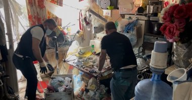 Municipal workers clear garbage from a house in Bursa, northwestern Türkiye, Sept. 17, 2025. (IHA Photo)