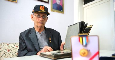 Hakkı Özgülbaş, 95, proudly displays the veteran’s medal he received after volunteering for the Korean War, in Adana, southern Türkiye, Sept. 17, 2025. (AA Photo)