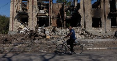 A man rides a bicycle past a damaged residential building in Novodonets&#039;ke, Donetsk region, Ukraine, Sept. 14, 2025. (AFP Photo)