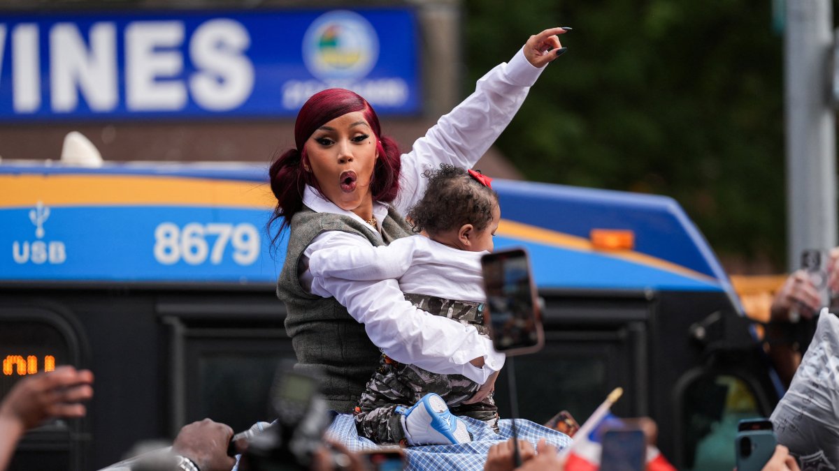 Rapper Cardi B holds a baby that was passed to her on the roof of her vehicle, as she hosts a pop-up event at a bodega, New York City, U.S., Sept. 13, 2025. (Reuters Photo)