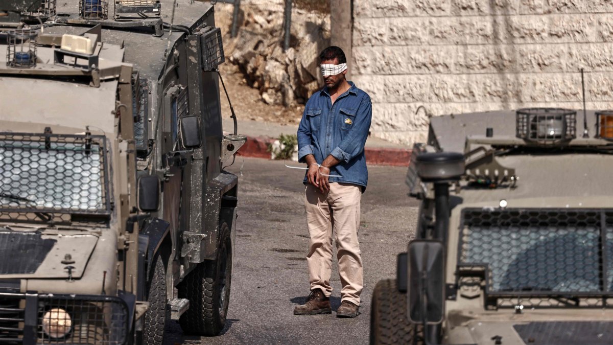 A Palestinian man stands with his hands tied and blindfolded during a raid by Israeli forces on Ramallah city in the occupied West Bank, Palestine, Sept. 16, 2025. (AFP Photo)