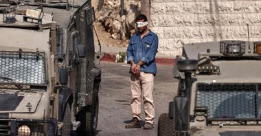 A Palestinian man stands with his hands tied and blindfolded during a raid by Israeli forces on Ramallah city in the occupied West Bank, Palestine, Sept. 16, 2025. (AFP Photo)