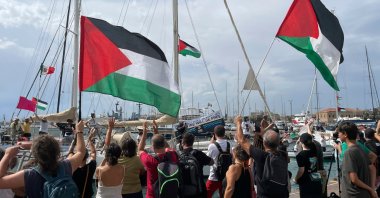 People carry Palestinian flags as they bid farewell to the Italian fleet of the Global Sumud Flotilla departing from the port of Siracusa, Italy, Sept. 11, 2025. (AP Photo)