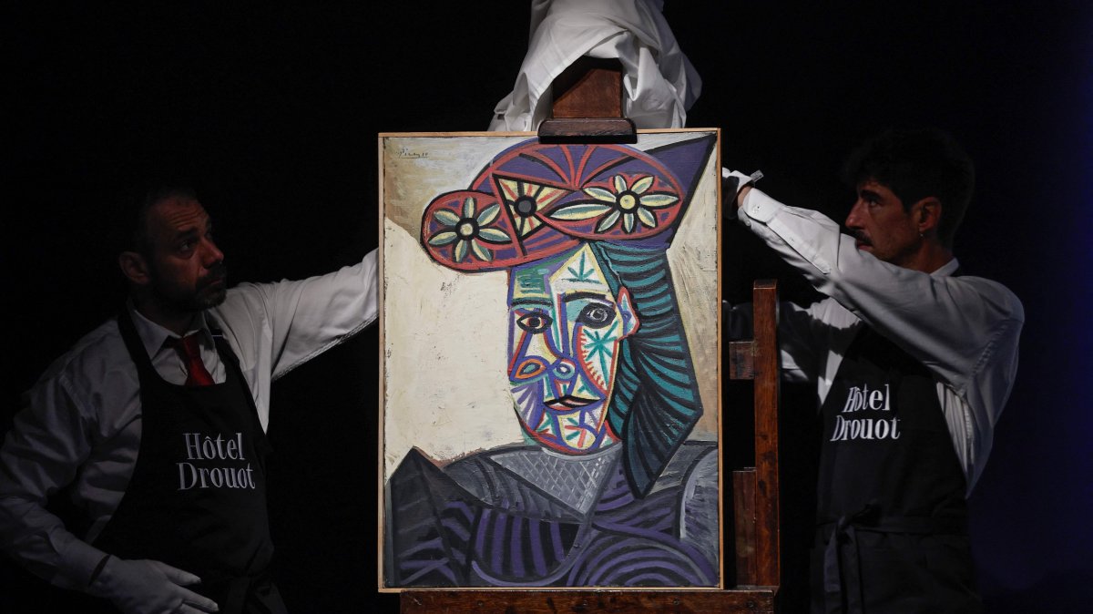 Employees unveal a painting by Spanish artist Pablo Picasso titled &quot;Bust of a woman with a flowery hat&quot; and featuring one his lovers Dora Maar, during its presentation at Hotel Drouot auction house, Paris, France, Sept. 18, 2025. (AFP Photo)
