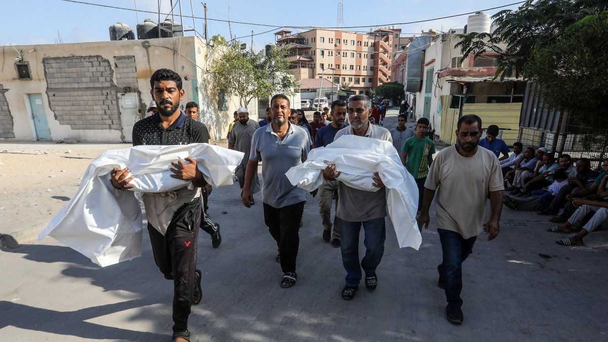 Two men carry the bodies of Palestinian children killed in Israeli airstrikes on the Khan Younis district, during a funeral ceremony at Nasser Hospital, Gaza Strip, Palestine, Sept. 18, 2025. (AA Photo)