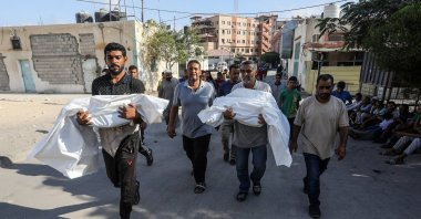 Two men carry the bodies of Palestinian children killed in Israeli airstrikes on the Khan Younis district, during a funeral ceremony at Nasser Hospital, Gaza Strip, Palestine, Sept. 18, 2025. (AA Photo)