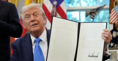 U.S. President Donald Trump displays a signed executive order on gold card visa in the Oval Office at the White House in Washington, D.C., U.S., Sept. 19, 2025. (Reuters Photo)