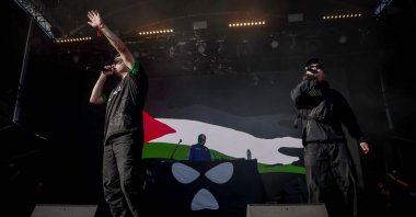 Northern Ireland hip-hop band Kneecap perform on stage in front of a Palestinian flag on a screen during a concert at the Rock en Seine music festival in Saint-Cloud, near Paris, on Aug. 24, 2025. (AFP Photo)