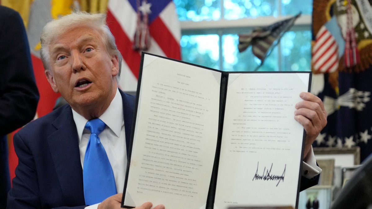 U.S. President Donald Trump displays a signed executive order on a gold card visa in the Oval Office at the White House in Washington, D.C., U.S., Sept. 19, 2025. (Reuters Photo)